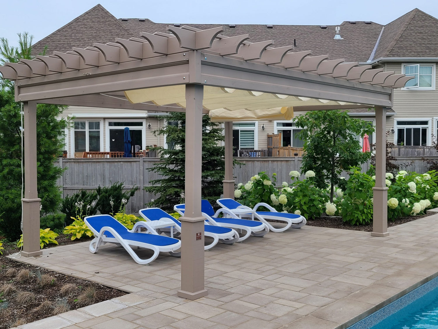 outdoor pool area with outdoor shade pergola providing shade over pool chairs