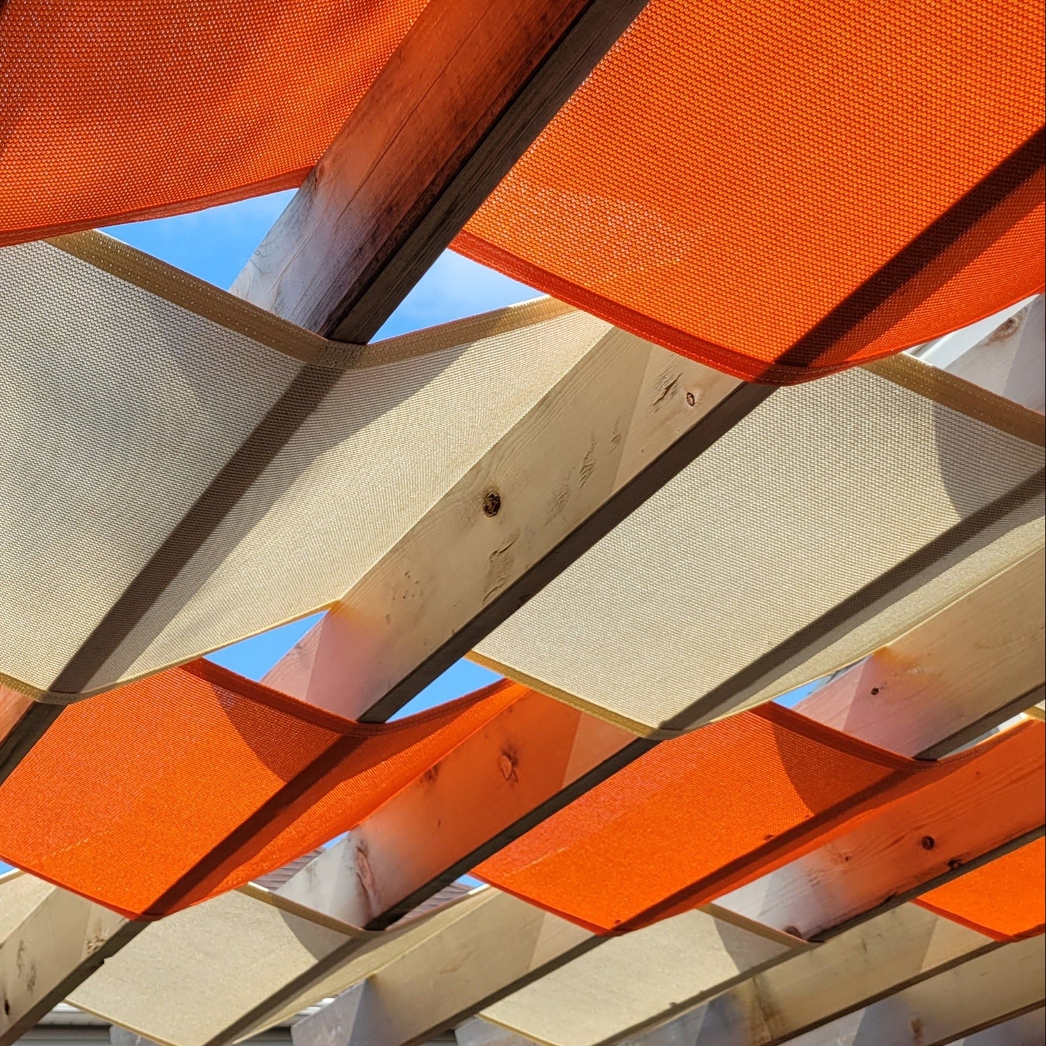 close up image of a orange and beige pergola shade showcasing how shade helps energy consumption