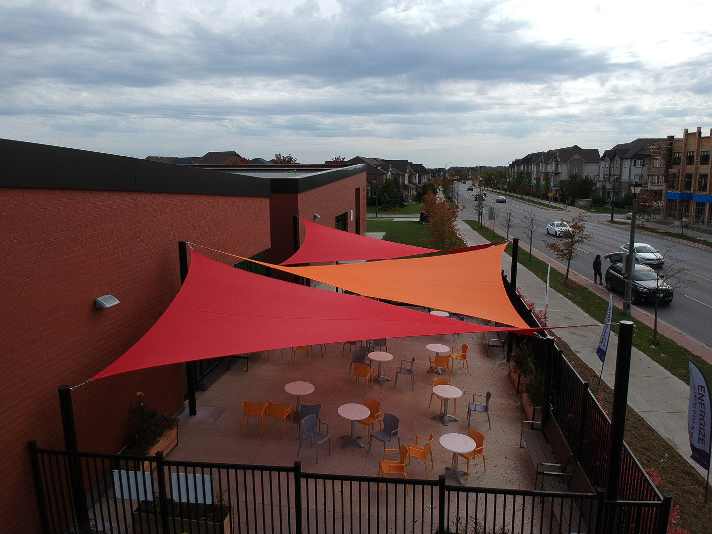 Three vibrant shade sails installed over an outdoor patio at the Southfield Community Centre, enhancing comfort and visual appeal for visitors.