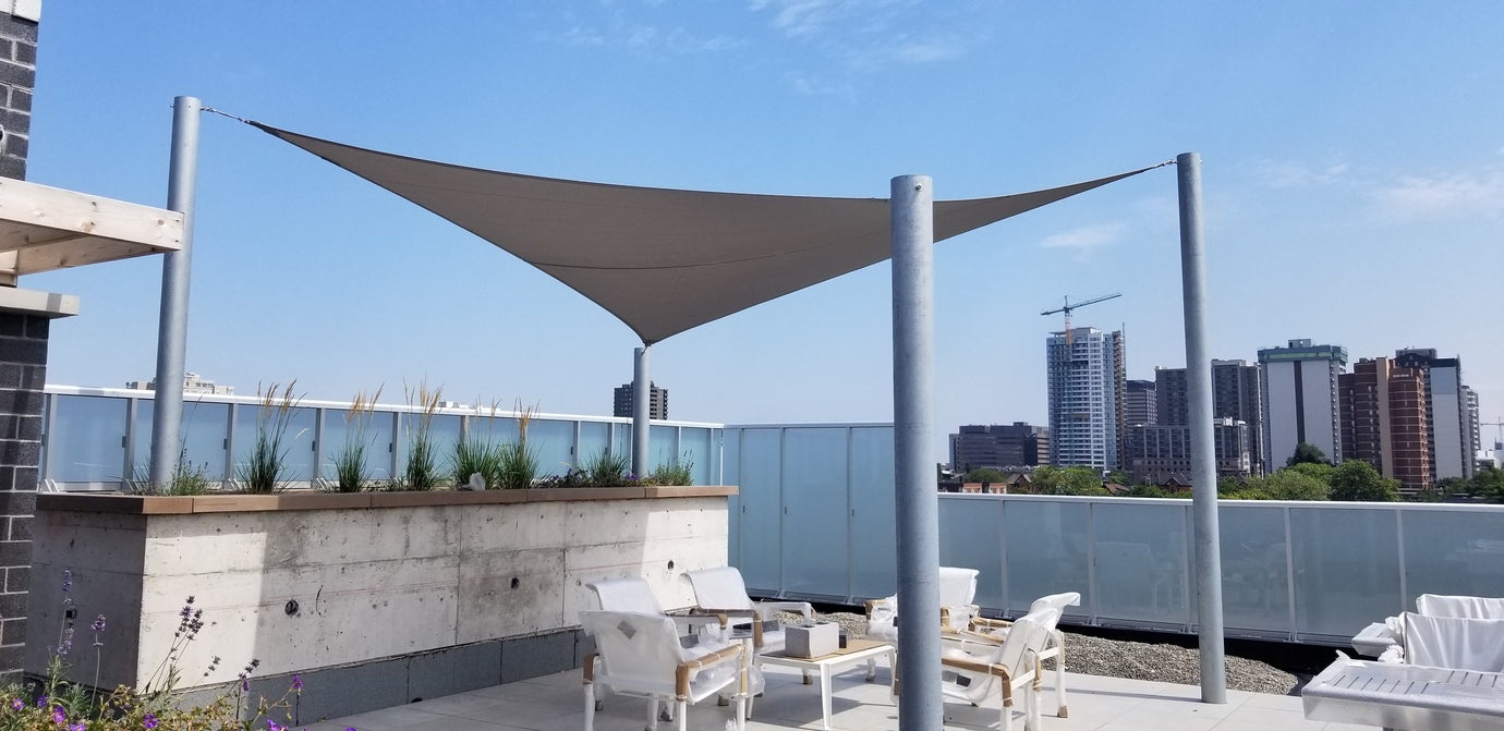 Image of a sun shade over a large balcony with a cityscape view.