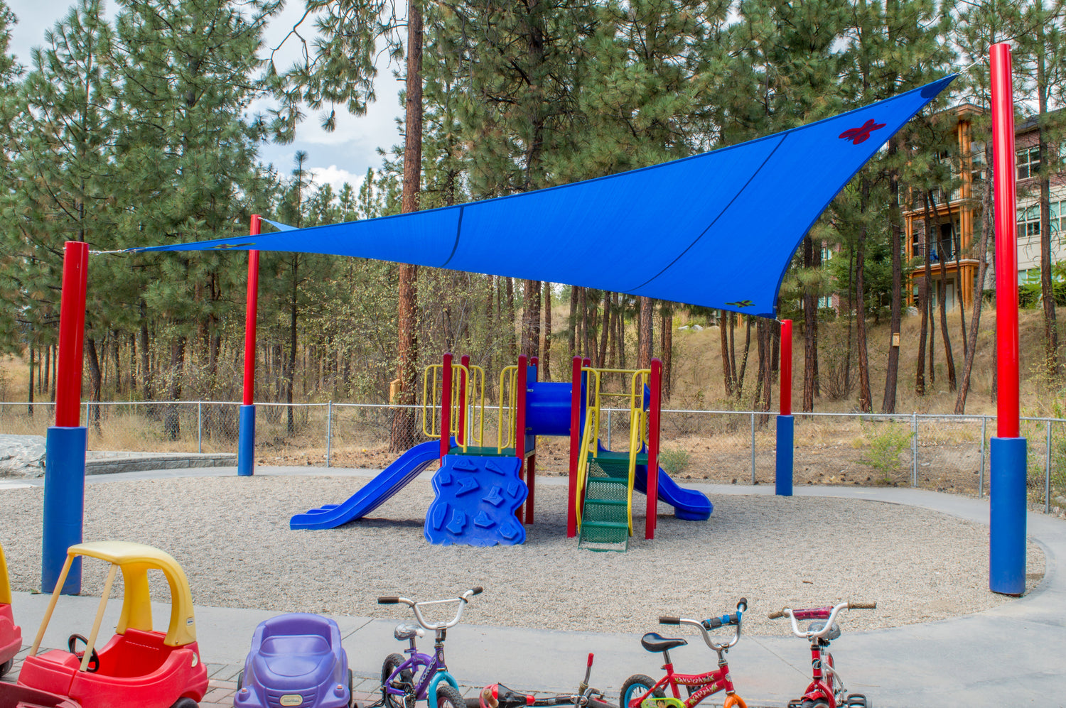 daycare playground with blue shade sail overhead providing custom shade solutions