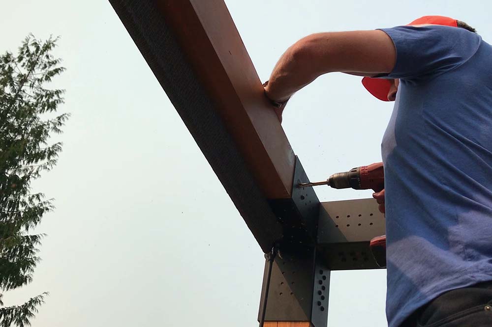 worker in blue shirt installing shade sails using shade sails hardware