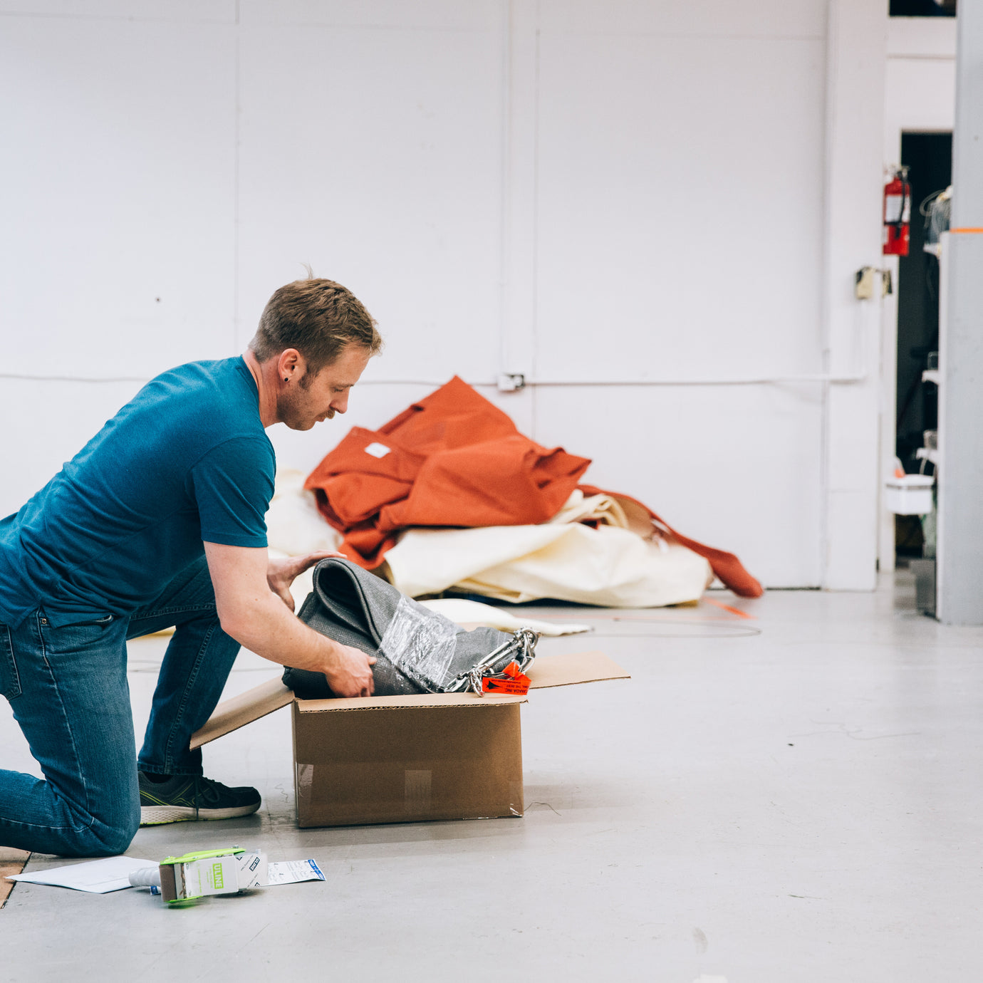 Image of Shade Sails employee opening a box with fabric for outdoor roll up blinds.