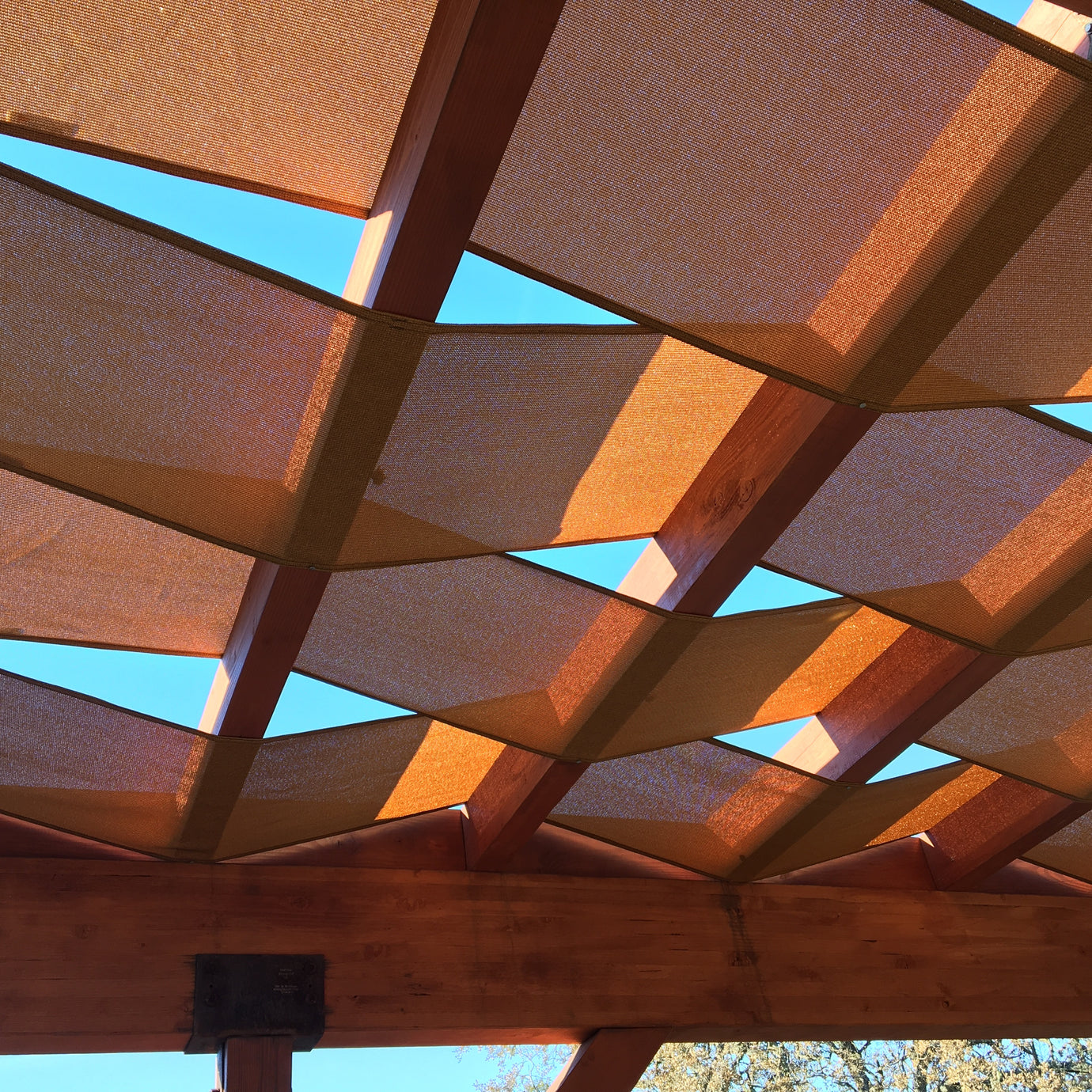 close up view of an orange pergola sail shade.