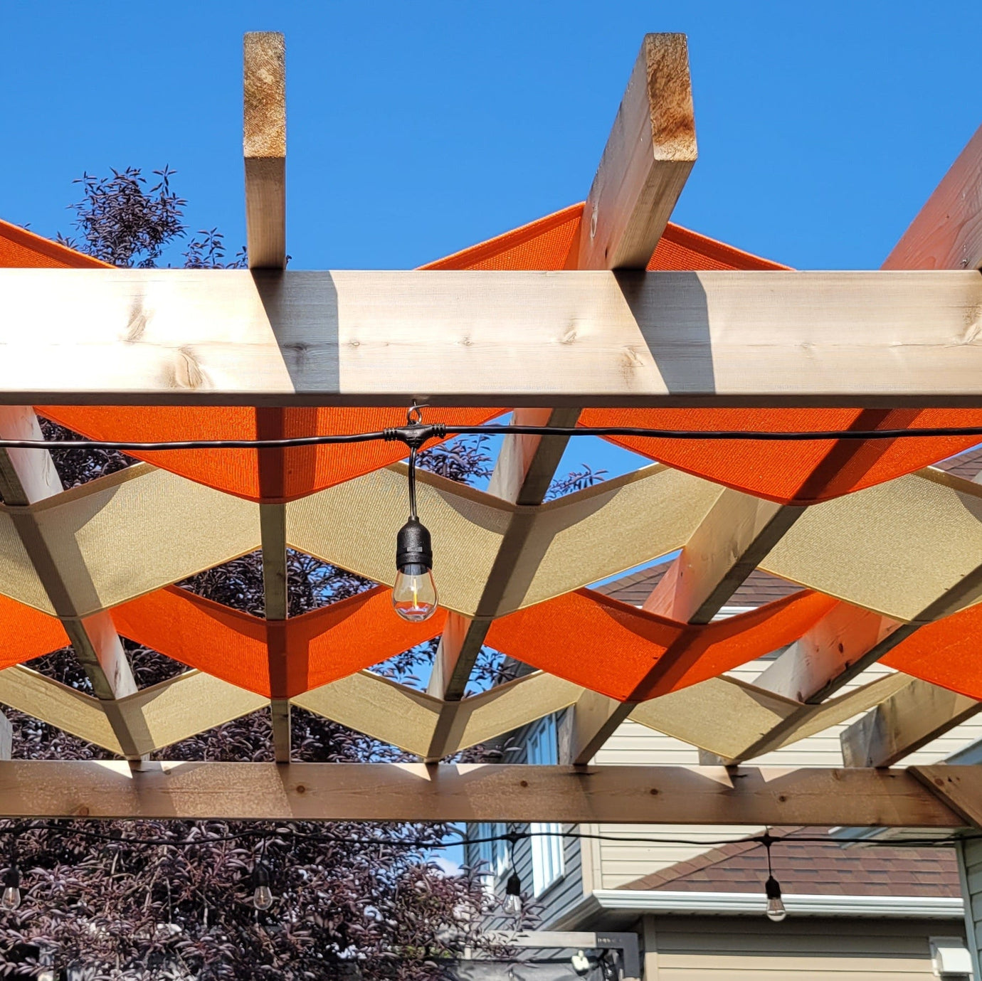 orange and beige shade on a pergola showcasing custom shade sail designs