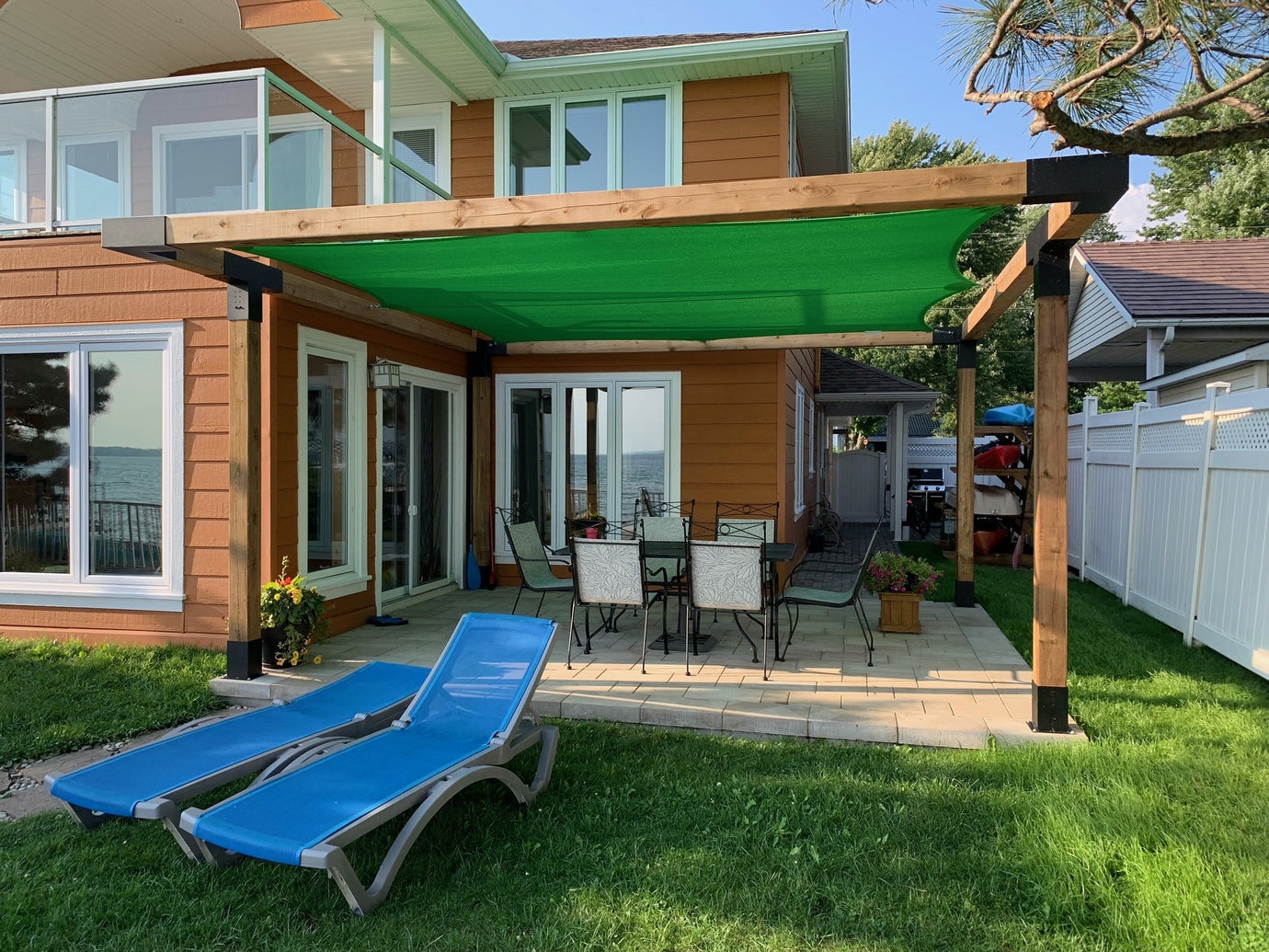 green sun shade sail in a backyard over a patio