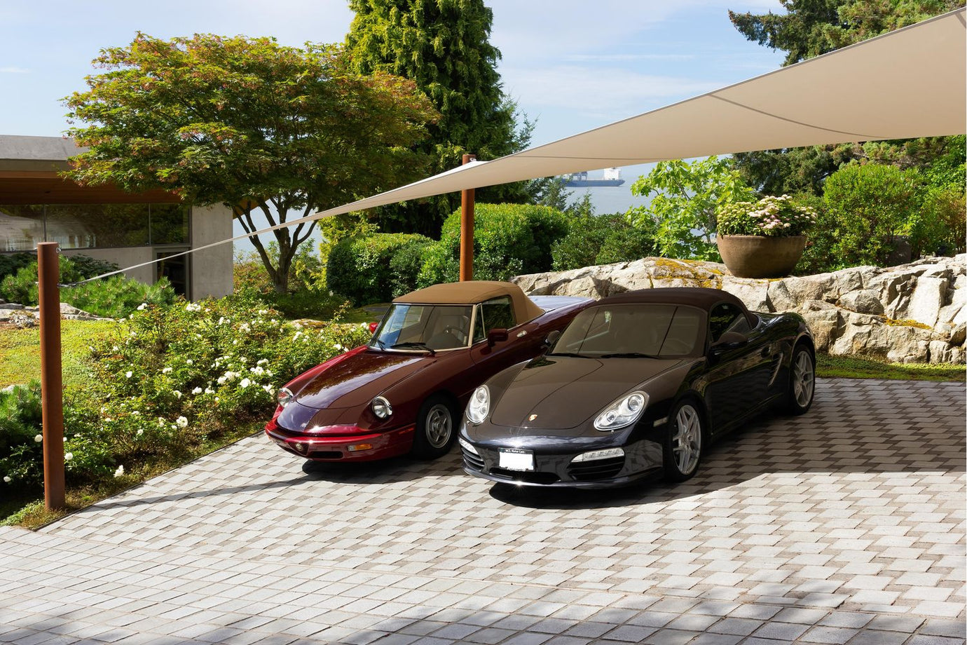 two cars in driveway with car shade ports covering them from the sun