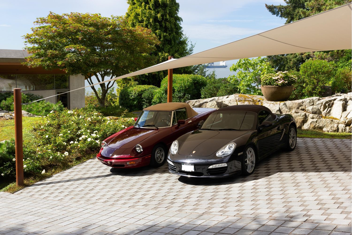two cars in driveway with car shade ports covering them from the sun