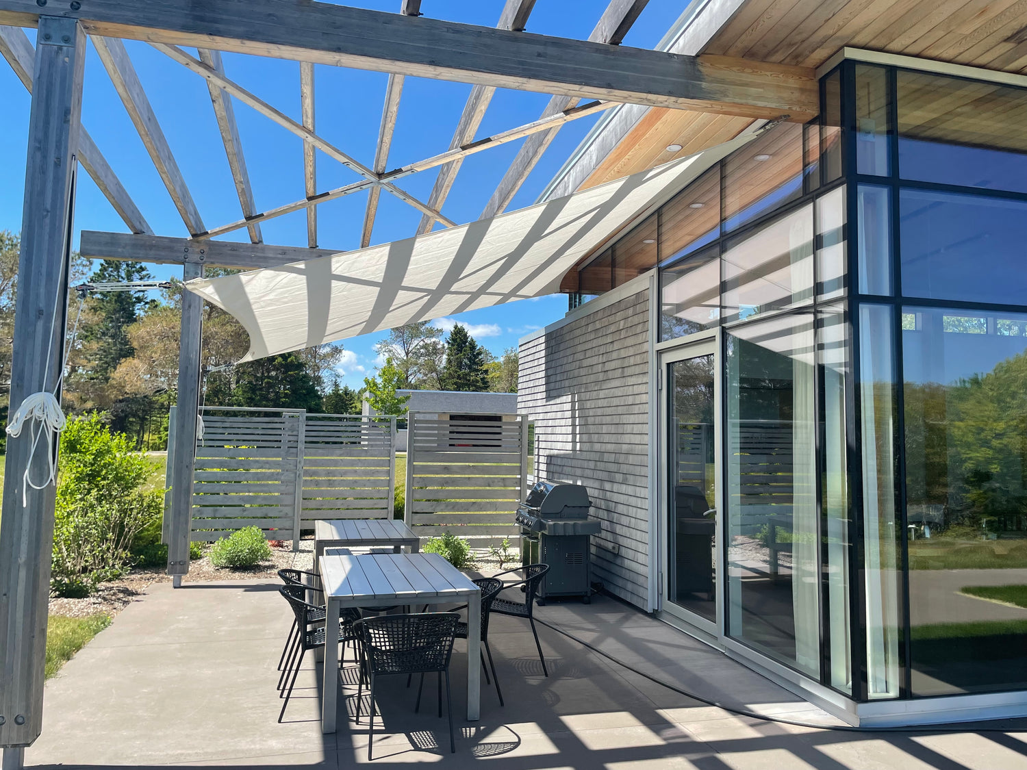 image of a backyard with an outdoor shade sail covering a patio.