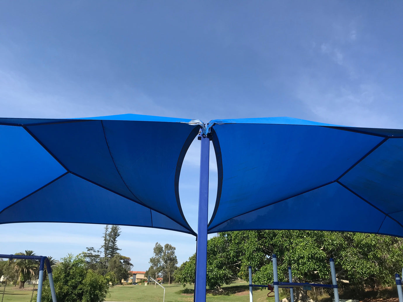 Close-up view of a vibrant blue pop-up sun shelter, with sturdy fabric and collapsible frame for outdoor shade and protection.