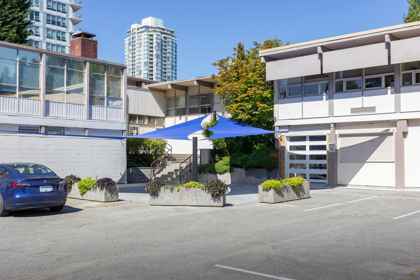 image of blue commercial shade sail creating a welcoming outdoor space for a business.