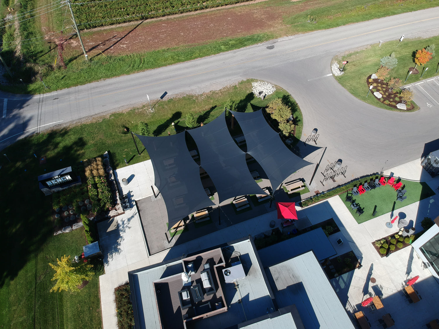 Aerial image of a workplace showcasing a black shade sail. This image shows a creative way for sun shade sail installation ideas.