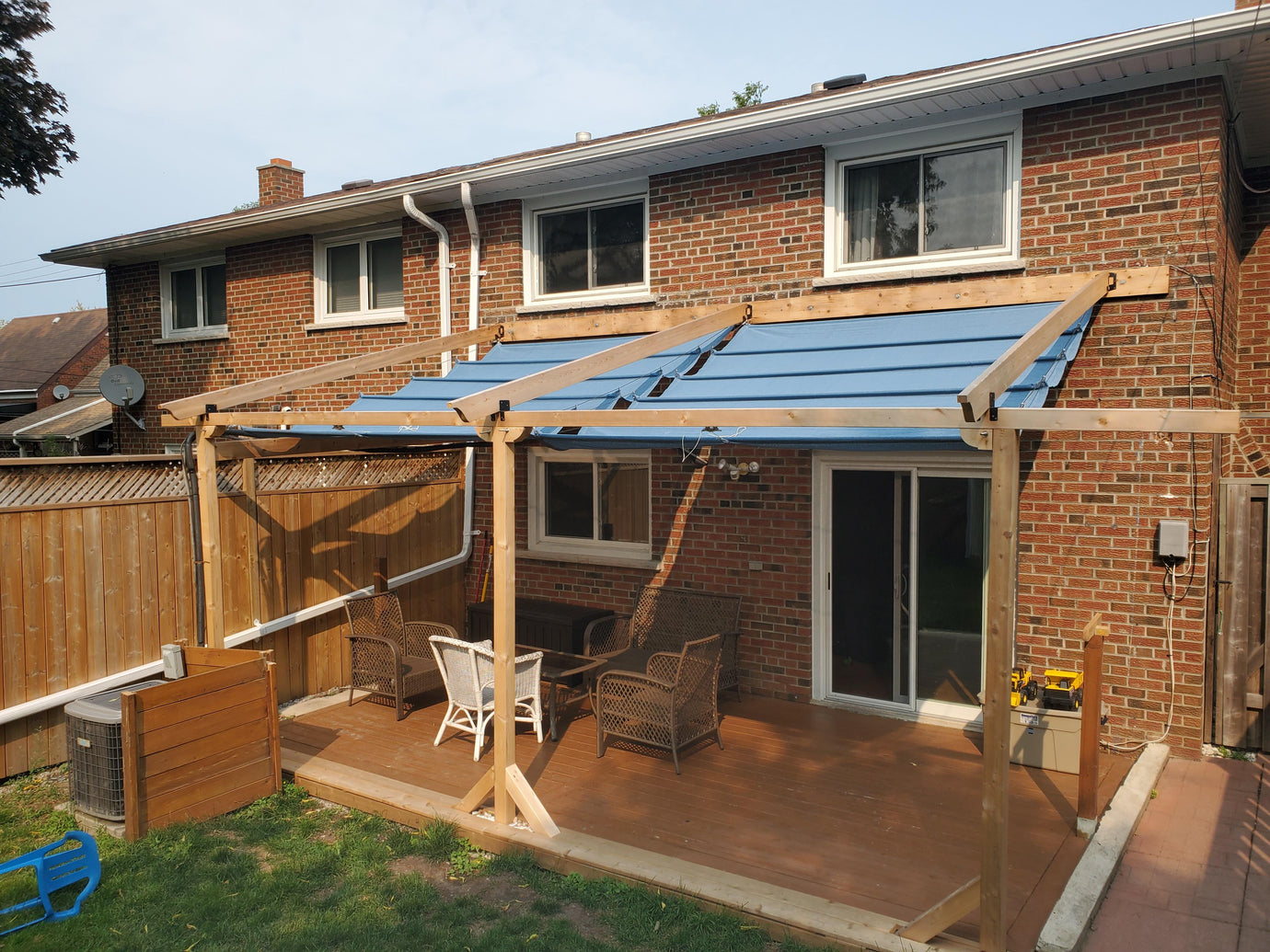 blue waterproof shade sails on back of house