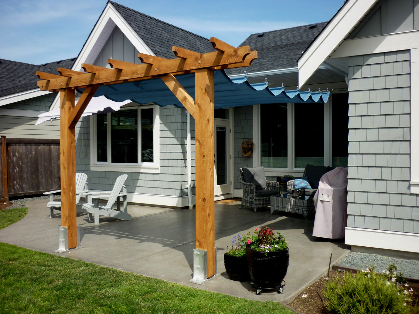 budget-friendly shade sail blue pergola attached to the backyard of a home