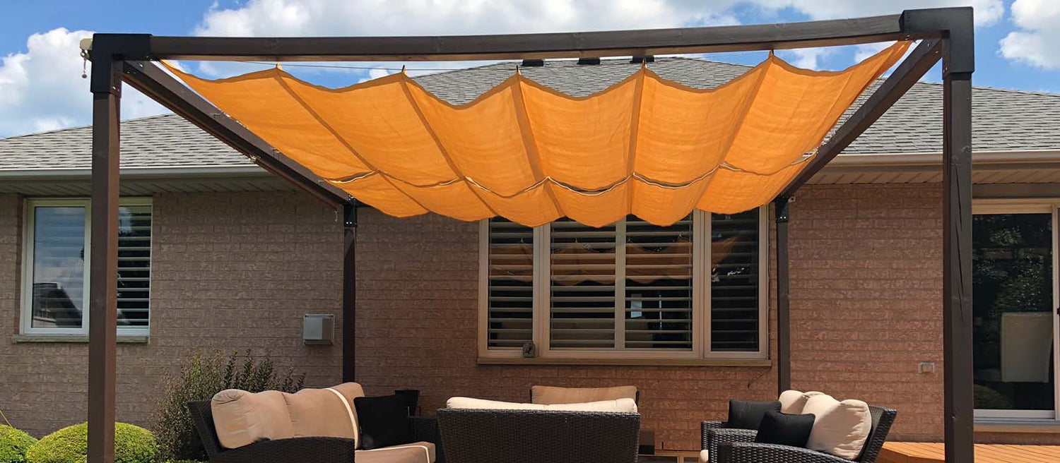 A backyard pergola shaded with bright orange Roman shades, illustrating a stylish and adjustable solution for homeowners exploring how to shade a pergola while enhancing both comfort and design in outdoor seating areas.