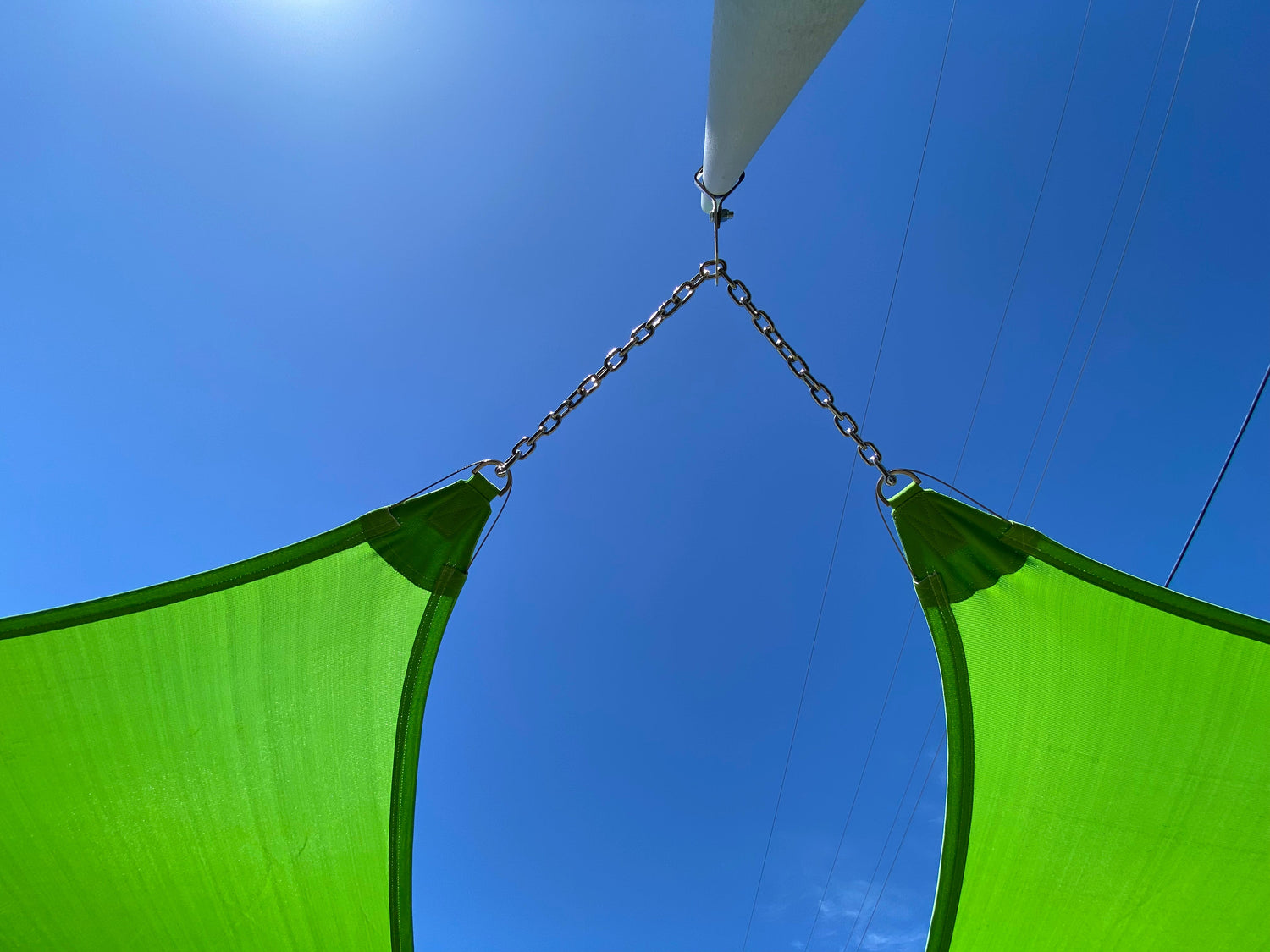 close up view of three green shade sails attached representing pickleball court shade structure