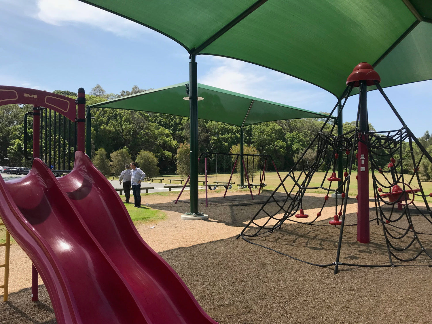Playground with slides and climbing structures covered by Waterproof Outdoor Shades, providing sun and weather protection for outdoor play areas.