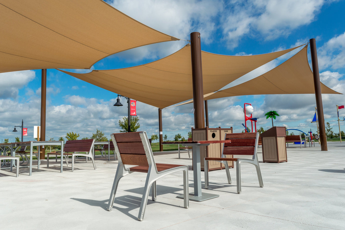 Public seating area covered with custom outdoor sun shades providing UV protection and modern shade for open-air gathering spaces.