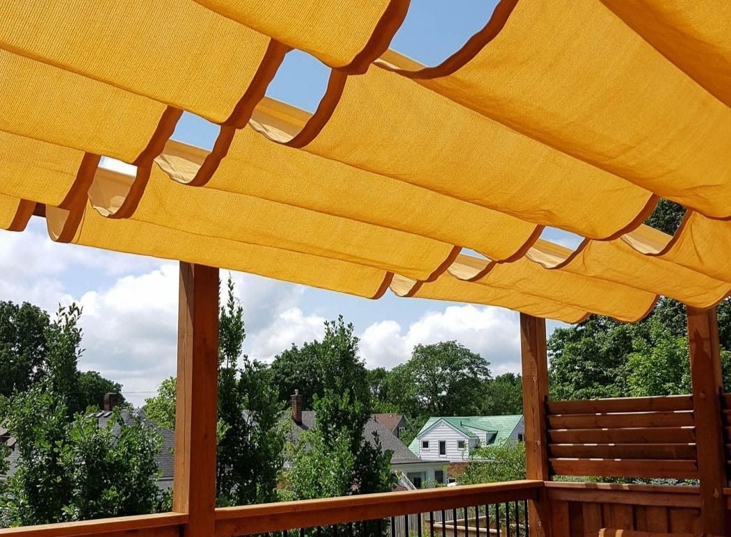 bright orange roman shade on a pergola in a backyard advertising roman shade hardware canada