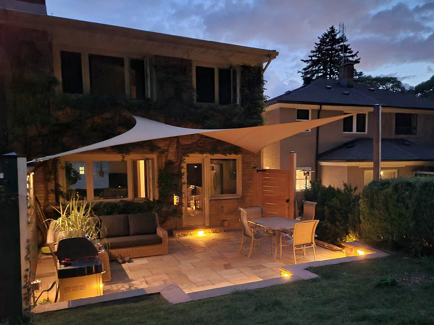 backyard with shade sail and lights on the patio showcasing how to increase property value.