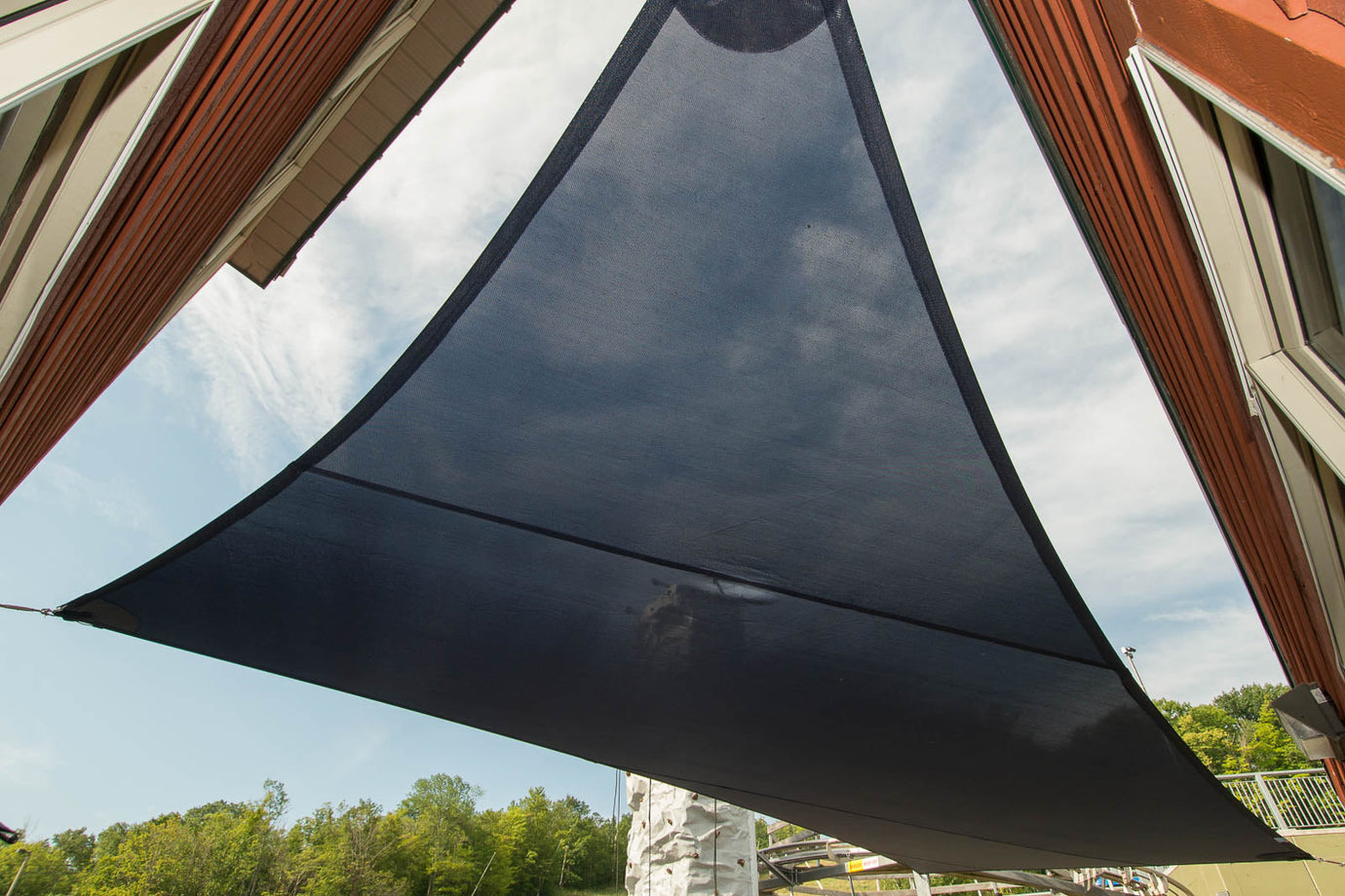Black shade sail installed with visible curved edges, visually demonstrating that the sides are not straight—highlighting why the sides of a shade sail are curved, not straight.