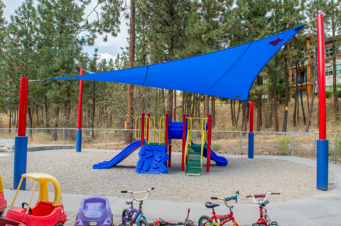 daycare playground with blue shade sail overhead providing custom shade solutions