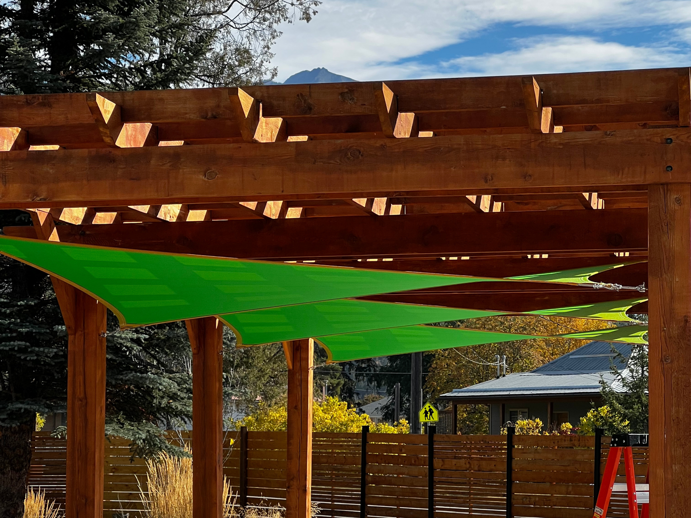 sun shade sail canopy under a pergola preventing the sun from a patio.