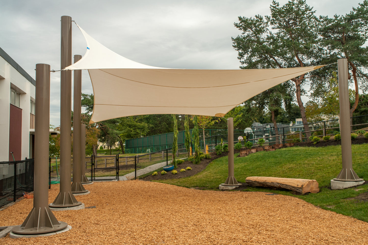 Beige impact canopy set up in a sunny yard, providing shade and a gathering space.