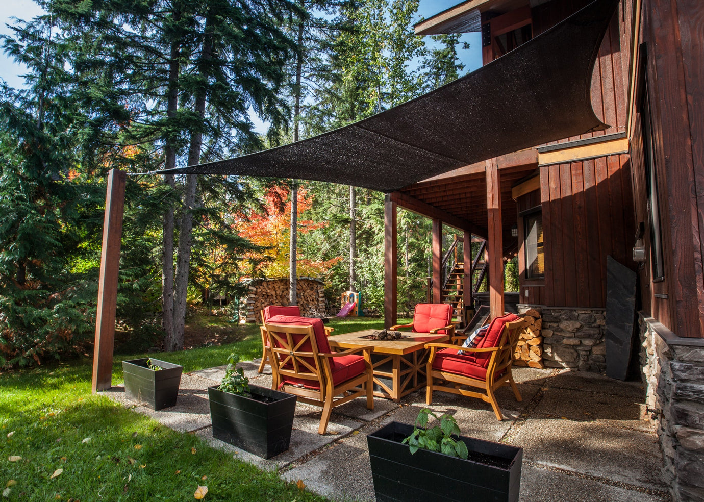 cozy backyard with forestry showcasing black backyard shade sails