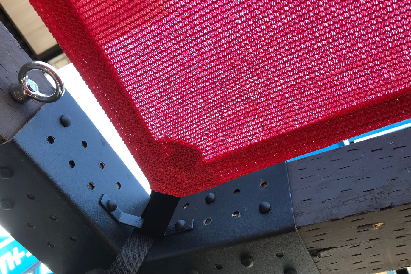 close up of red shade attached to shade anchor representing why shaded pickleball courts are a must-have 